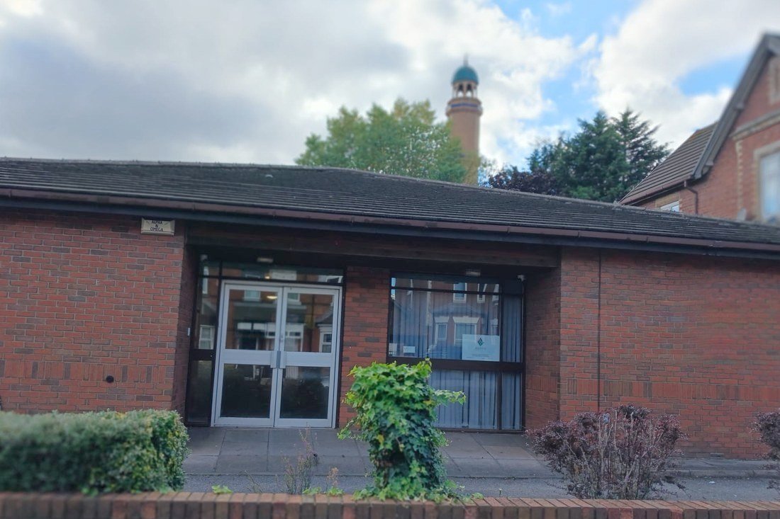 The entrance to Aspire 2 in Smethwick, a single-storey red brick building with a covered porch and glazed double doors