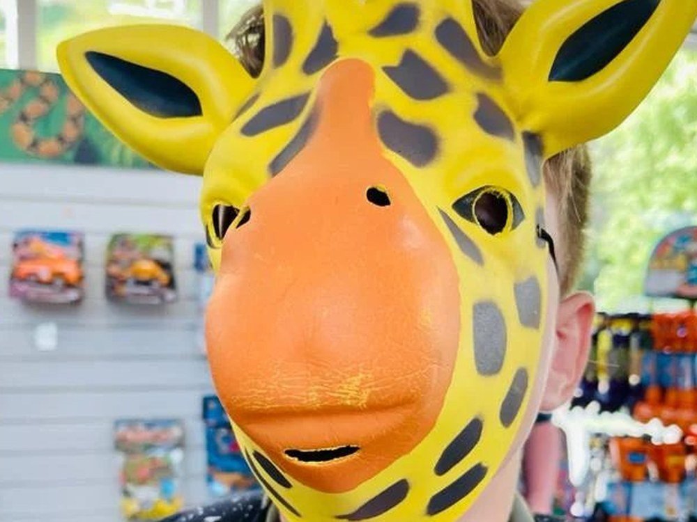 A student wearing a giraffe mask on a trip out