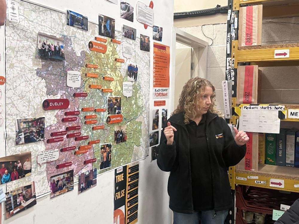 A Black Country Foodbank worker talking students through a wall map of the centres they supply across Walsall, Dudley and Sandwell